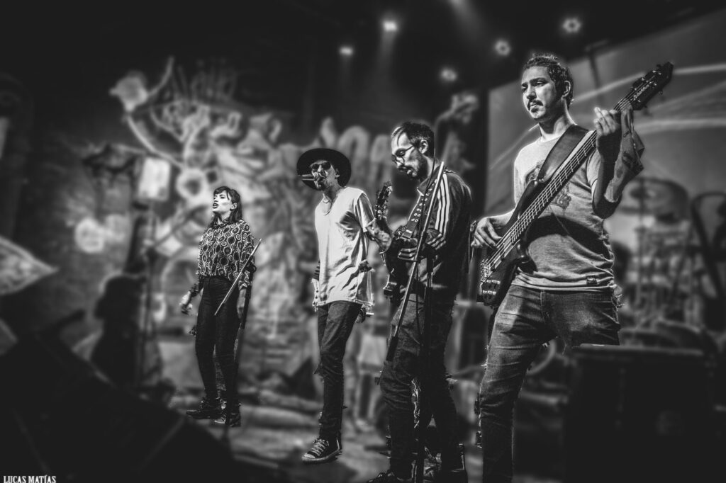 Los cuatro integrantes de La Tico tocando en vivo, celebrando diez años de la banda formada en Collegium